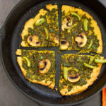 Socca Pizza with chimichurri and mushrooms on cast iron skillet