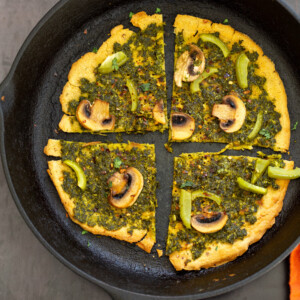 Socca Pizza with chimichurri and mushrooms on cast iron skillet