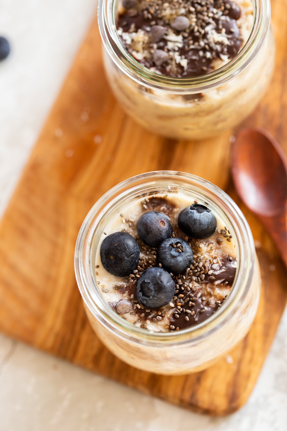 vegan pantry recipes overhead shot of Vegan Samoa Cookie Overnight Oats in glass jars on a wood board