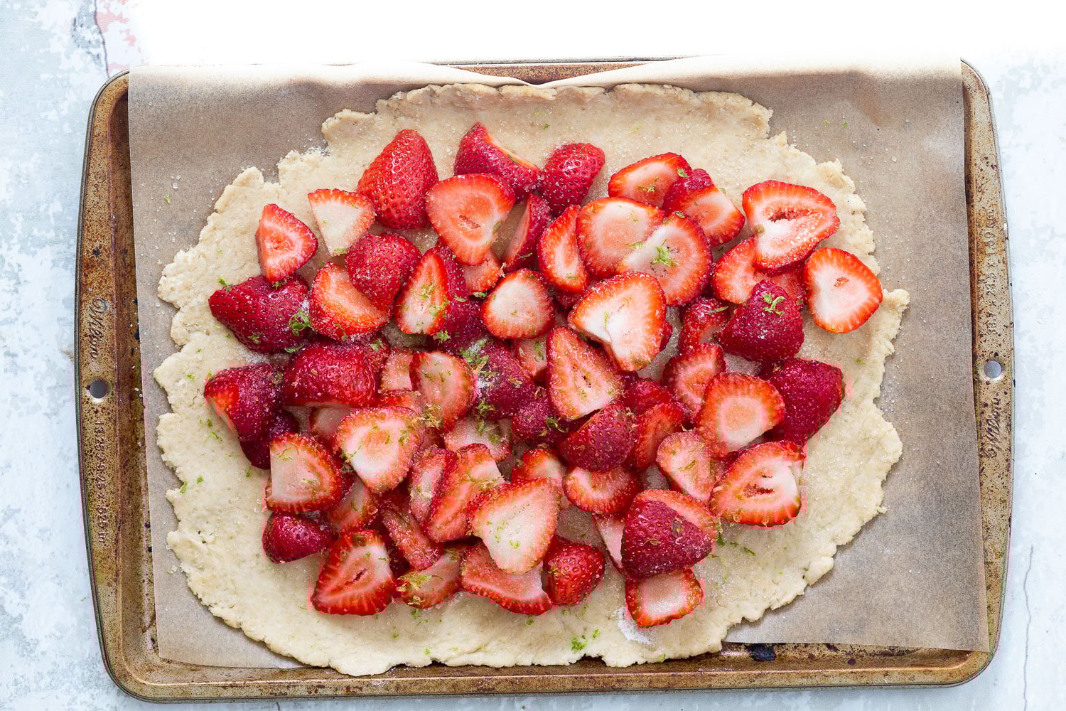 Strawberries on crust for our Vegan Strawberry Galette on parchment