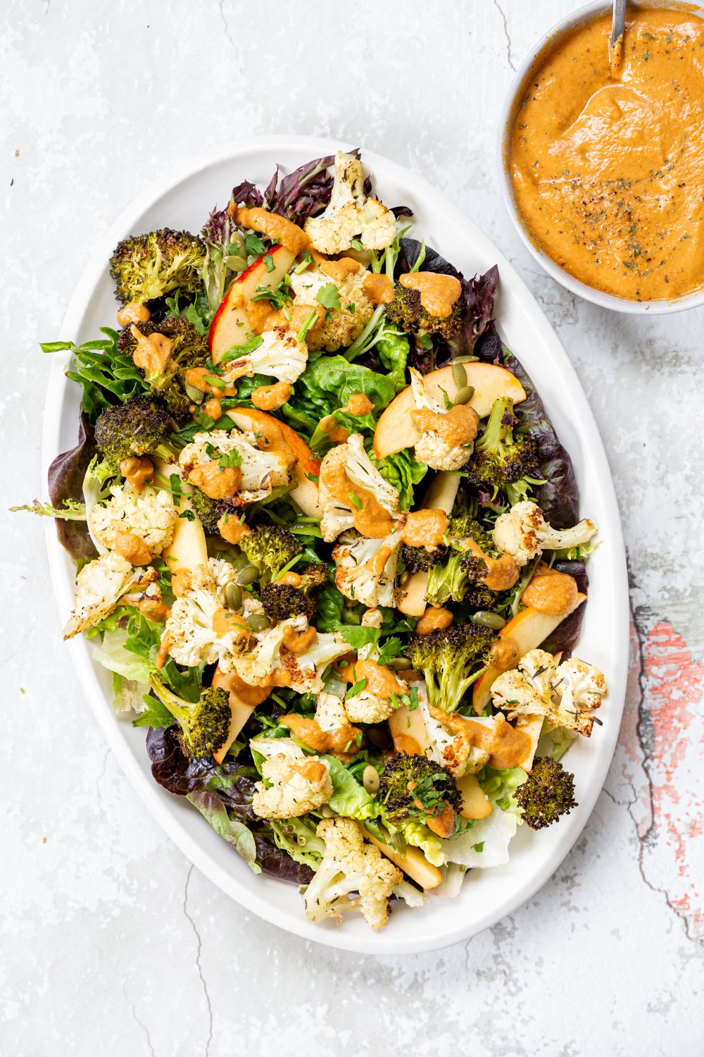 Roasted Broccoli Cauliflower Salad with Sun dried Tomato Dressing on white serving platter