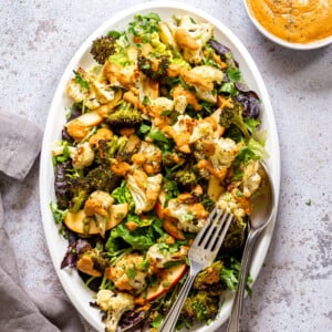Roasted Broccoli Cauliflower Salad with Sun dried Tomato Dressing on white serving platter