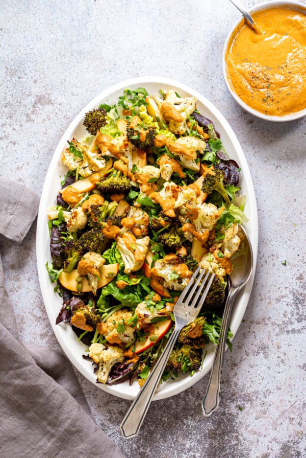 Roasted Broccoli Cauliflower Salad with Sun dried Tomato Dressing on white serving platter