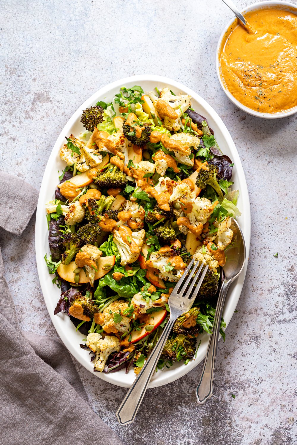 Roasted Broccoli Cauliflower Salad with Sun dried Tomato Dressing on white serving platter
