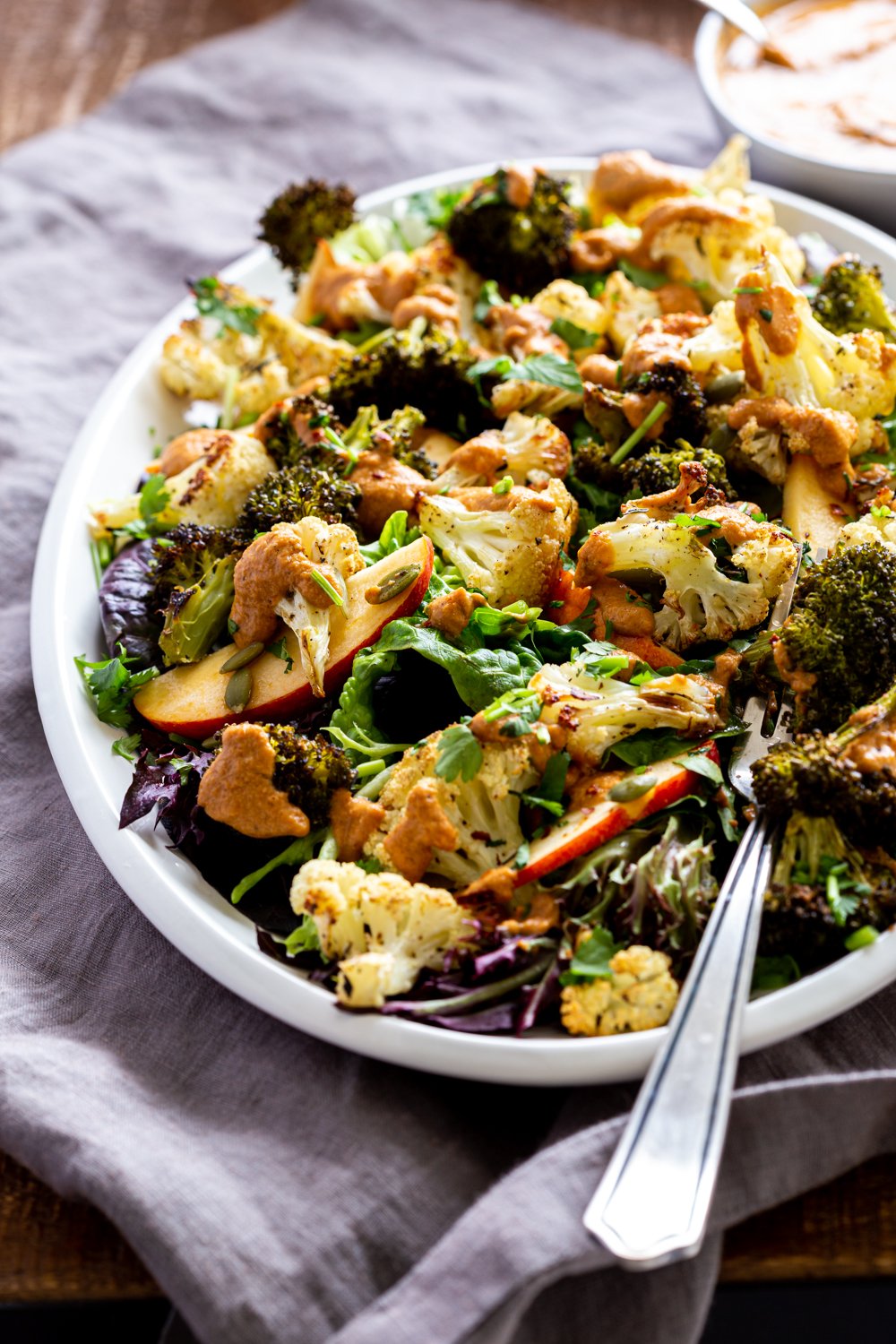 Roasted Broccoli Cauliflower Salad with Sun dried Tomato Dressing on white serving platter