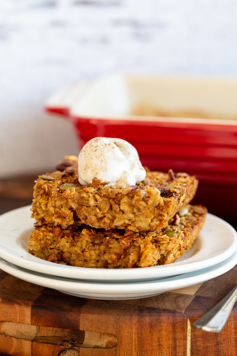 Our Vegan Pumpkin Baked Oatmeal on white plate on a wood cutting board