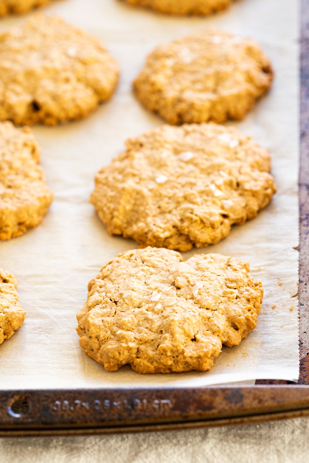 Our Vegan Gluten-free Tahini Oatmeal Cookies on a parchment lined sheet