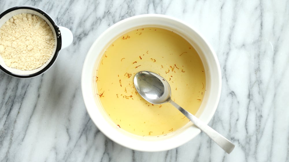 Sugar and saffron mixture for our Almond Halwa in white baking dish