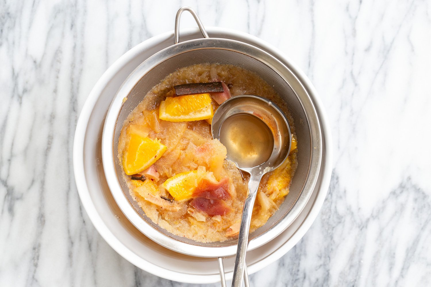Cooked Instant Pot Apple Cider in a strainer