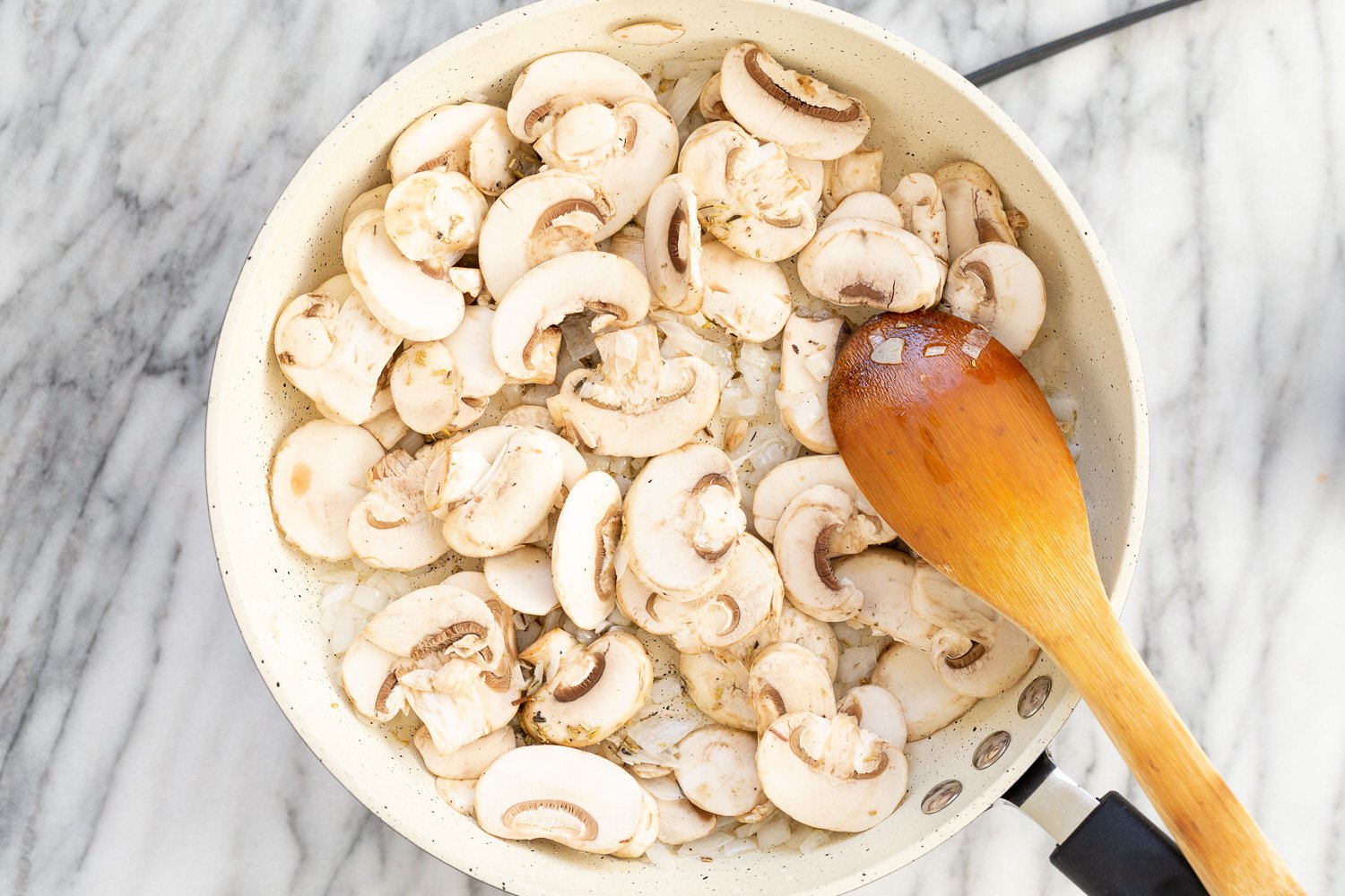 onion and mushrooms in a white skillet