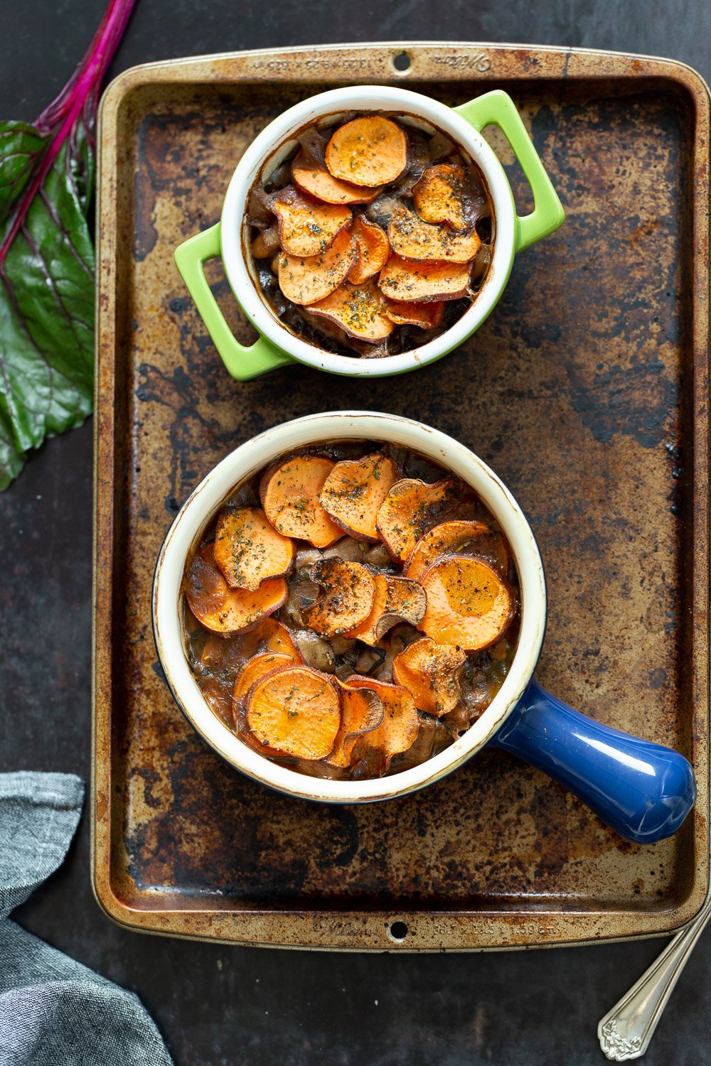Our Vegan Mushroom Pot Pie in green and blue baking dishes on a baking sheet