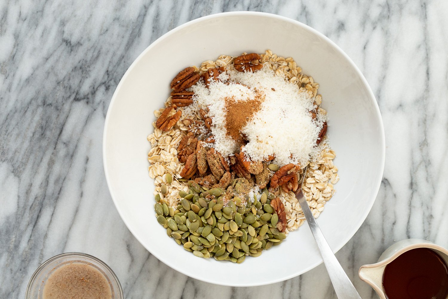 Ingredients for our Maple Pecan Granola in a white bowl