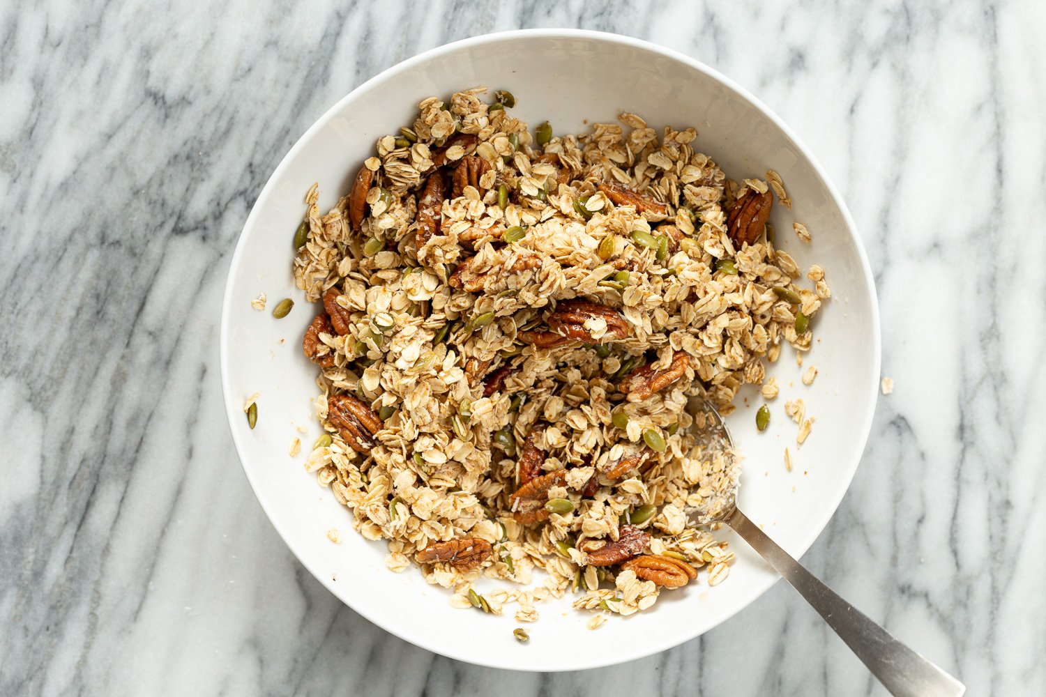Ingredients for our Maple Pecan Granola in a white bowl