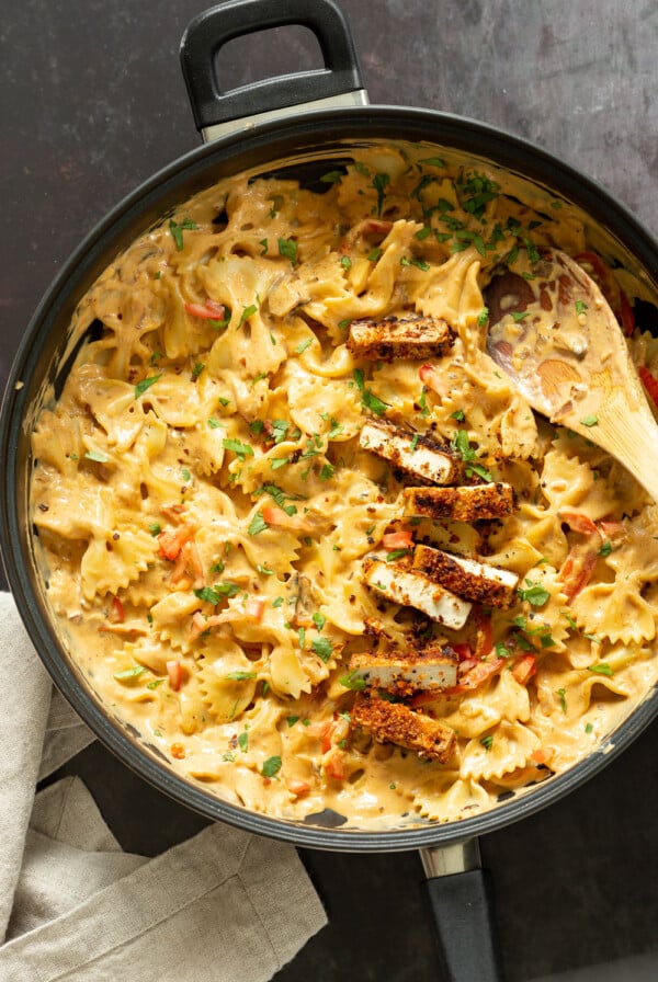 Vegan Creamy Cajun Pasta with Crisp Breaded tofu in a black skillet