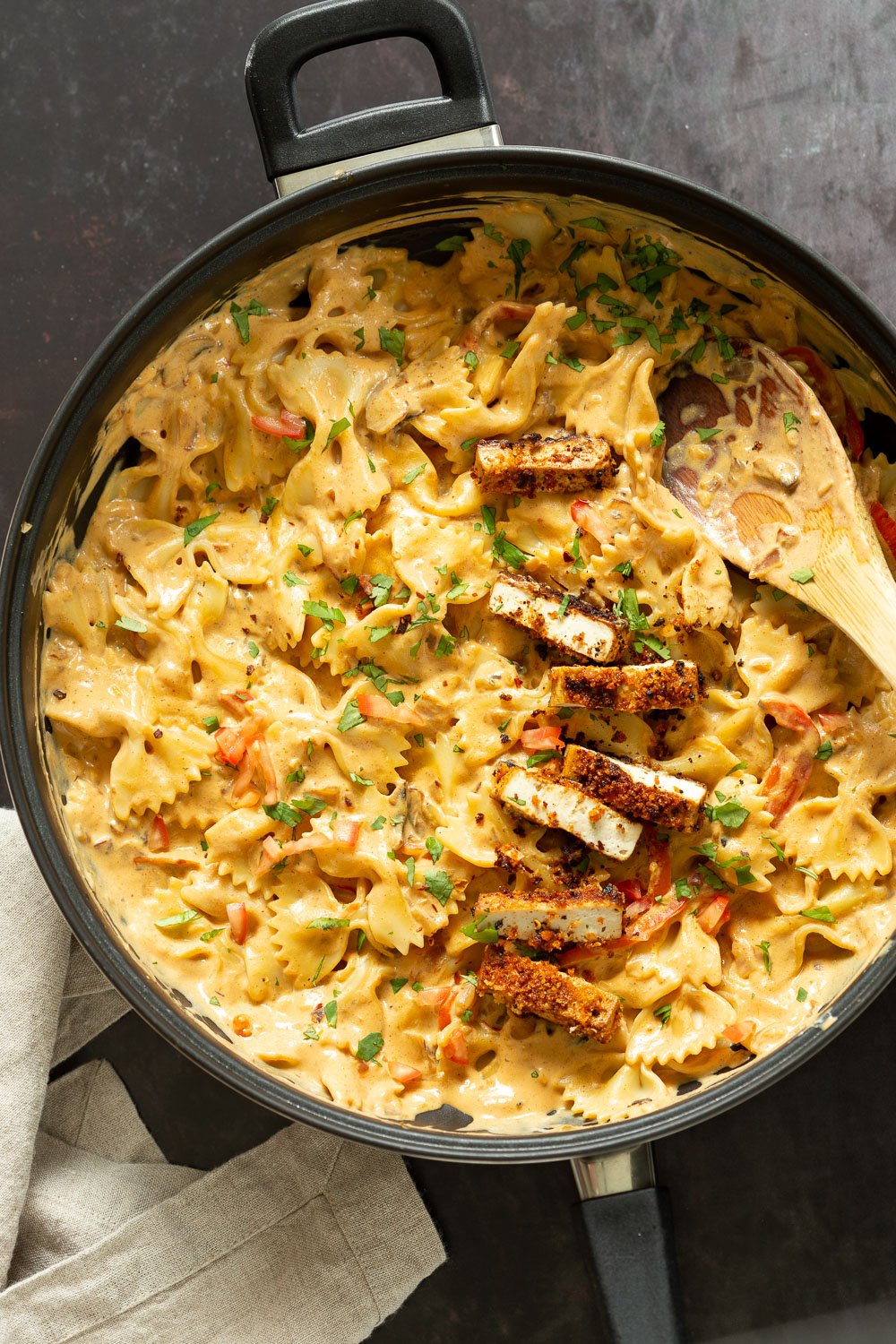 Vegan Creamy Cajun Pasta with Crisp Breaded tofu in a black skillet