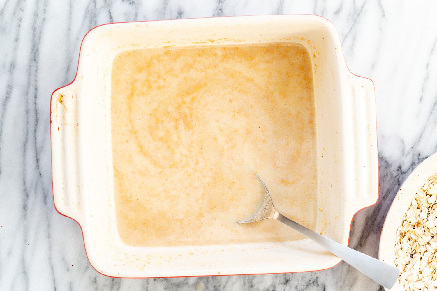Ingredients for Peanut Butter and Jelly Oatmeal in a white baking dish