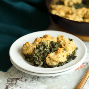 Vegan Creamed spinach in white plate and iron skillet