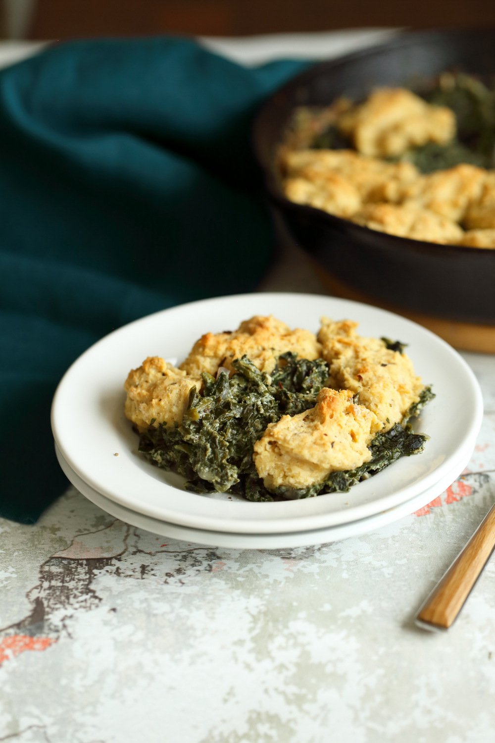 Vegan Creamed spinach in white plate and iron skillet