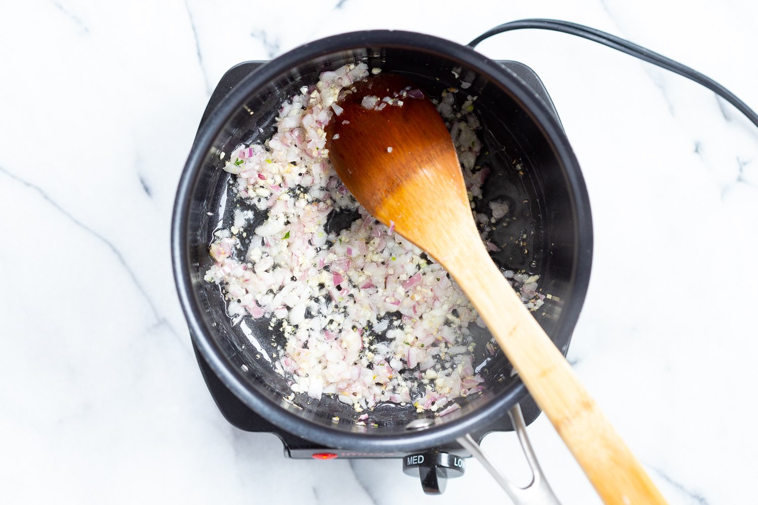 Ingredients for chunky marinara sauce in a black saucepan