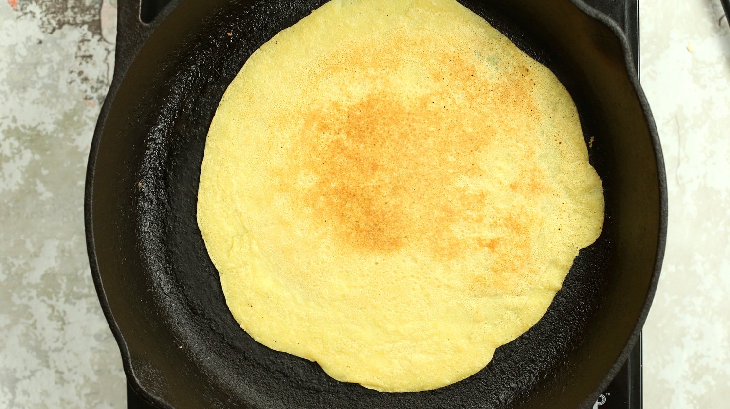 Plain Vegan Omelet made with Mung Beans on a cast iron skillet