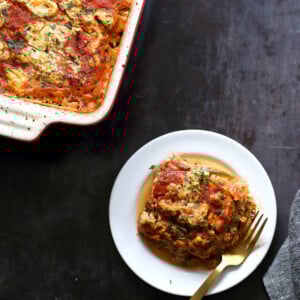 Our Vegan Gluten free Zucchini Lasagna in a cream baking dish and white plate