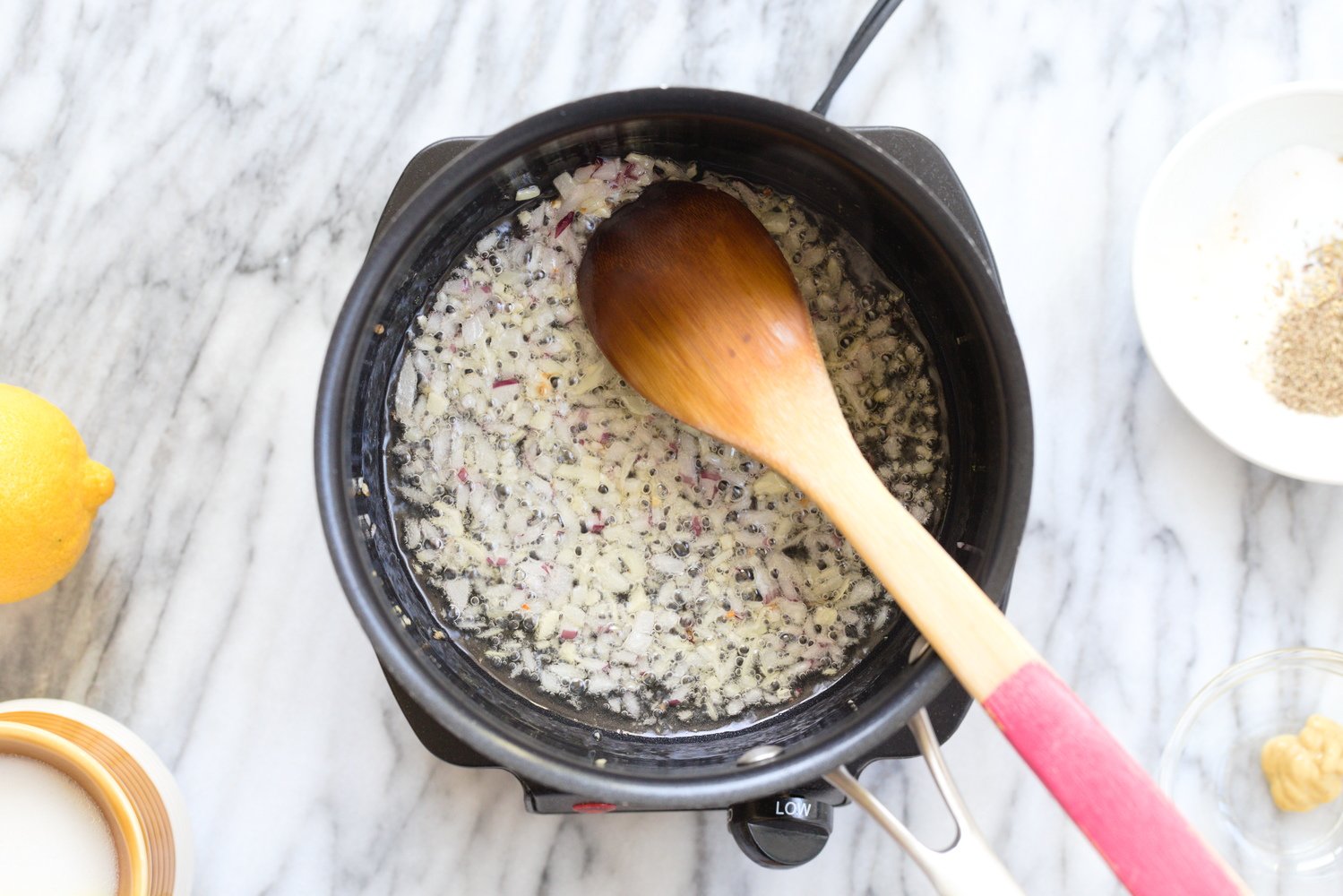onion and garlic in a black saucepan