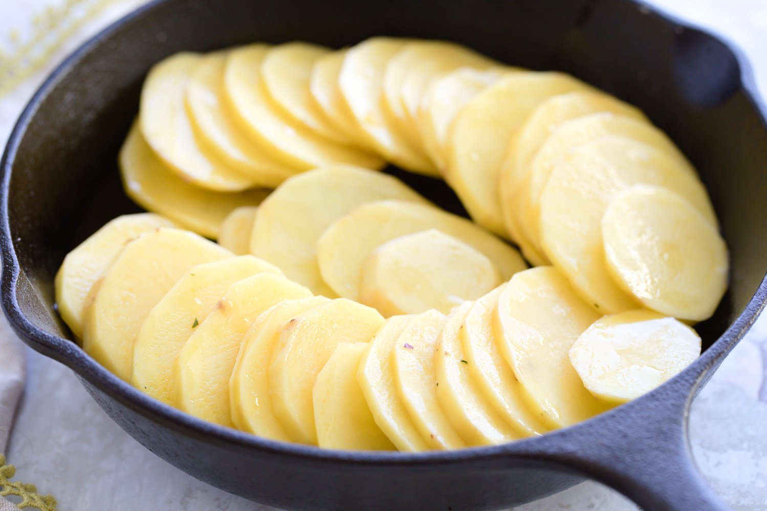 sliced potatoes in a cast iron skillet