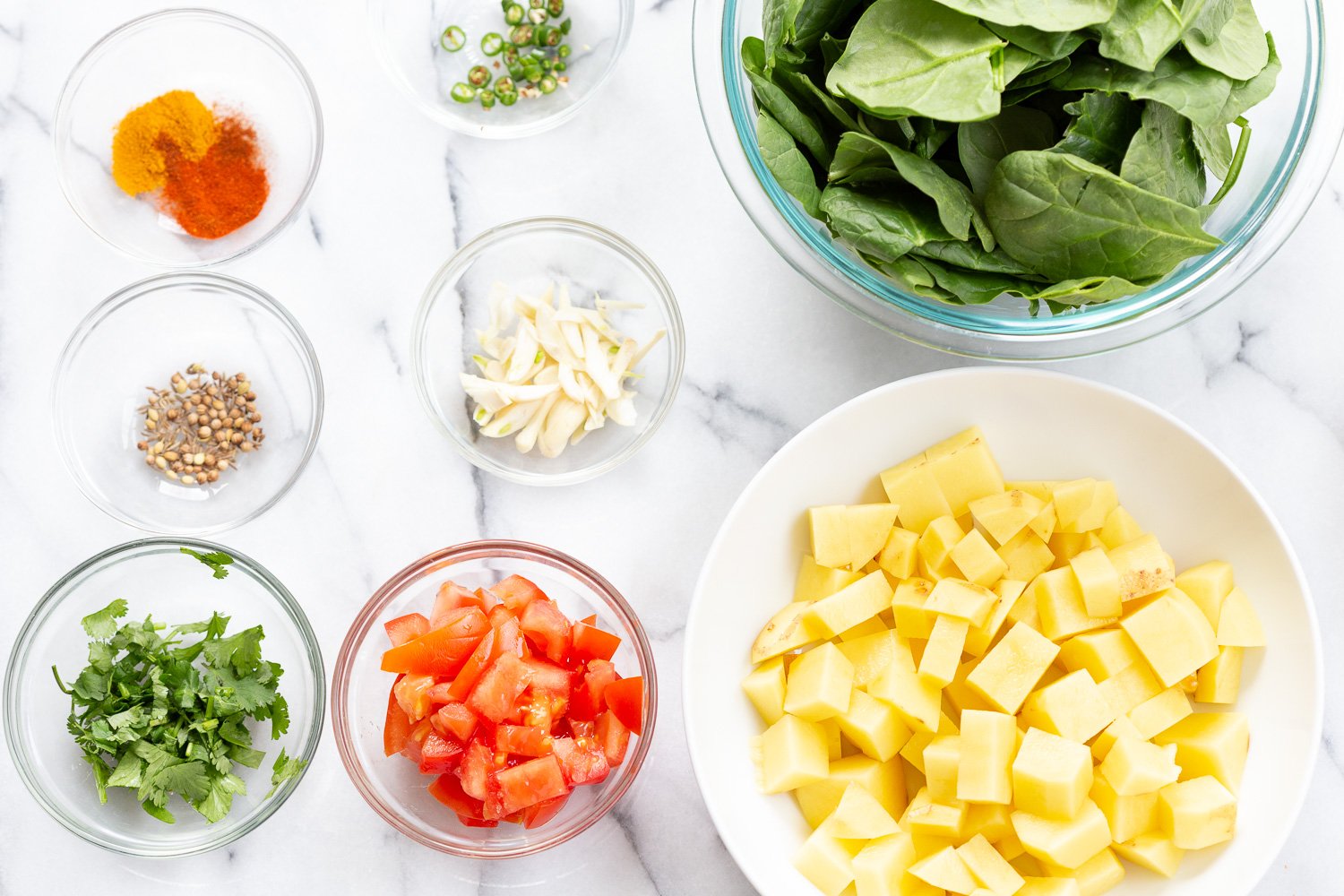 Ingredients for Garlic Potato Spinach Stir fry in bowls