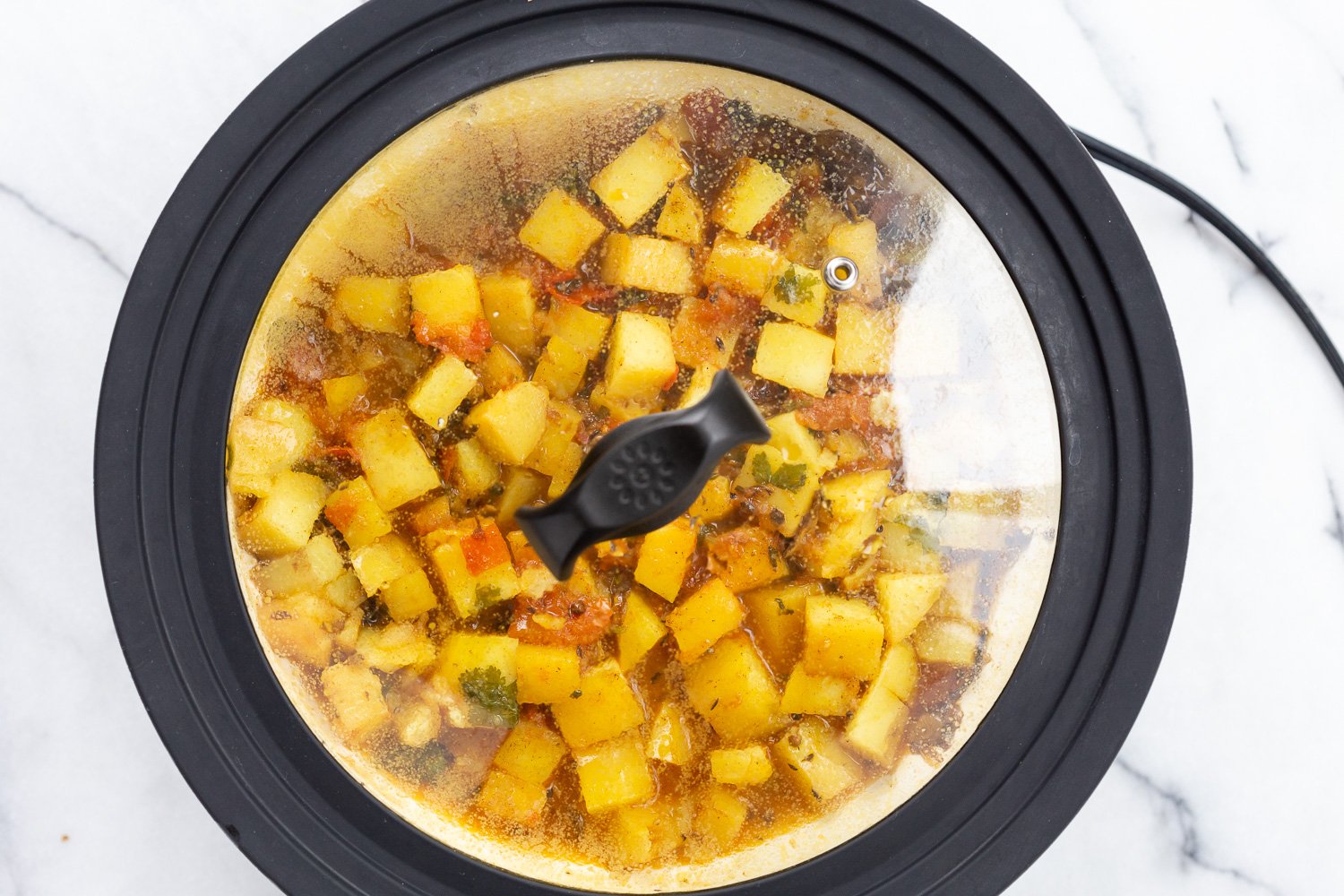 Potatoes and tomatoes in white skillet