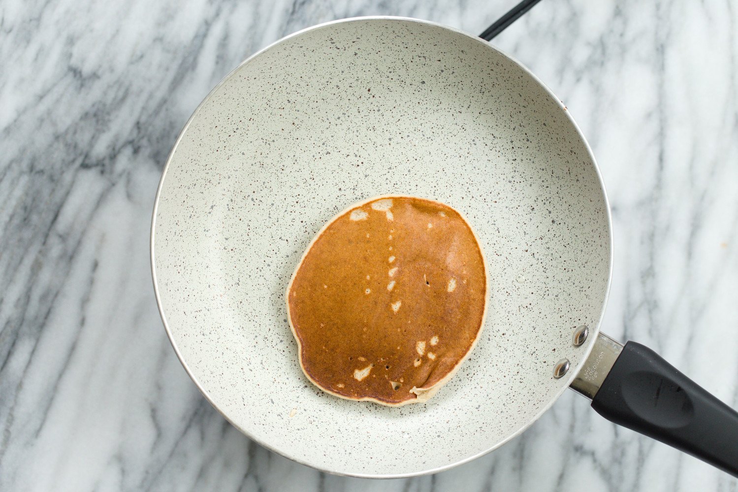 Vegan Banana Oat Pancake batter on white stone skillet