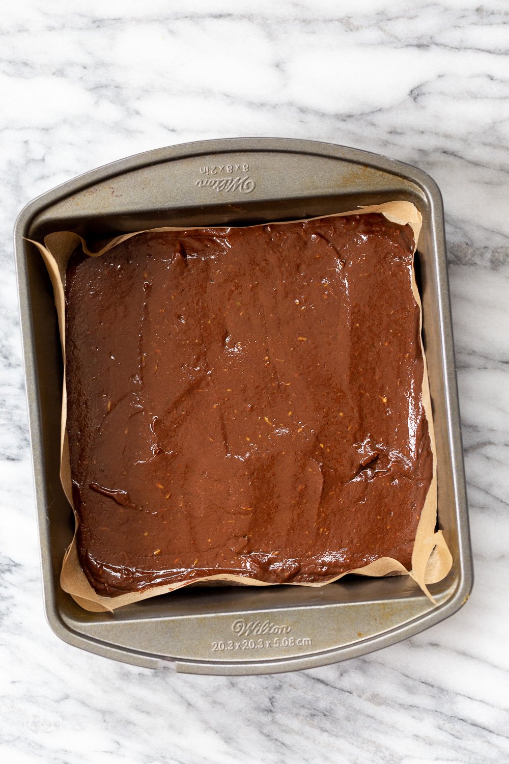 Vegan Chocolate Avocado Freezer Fudge in parchment lined brownie pan