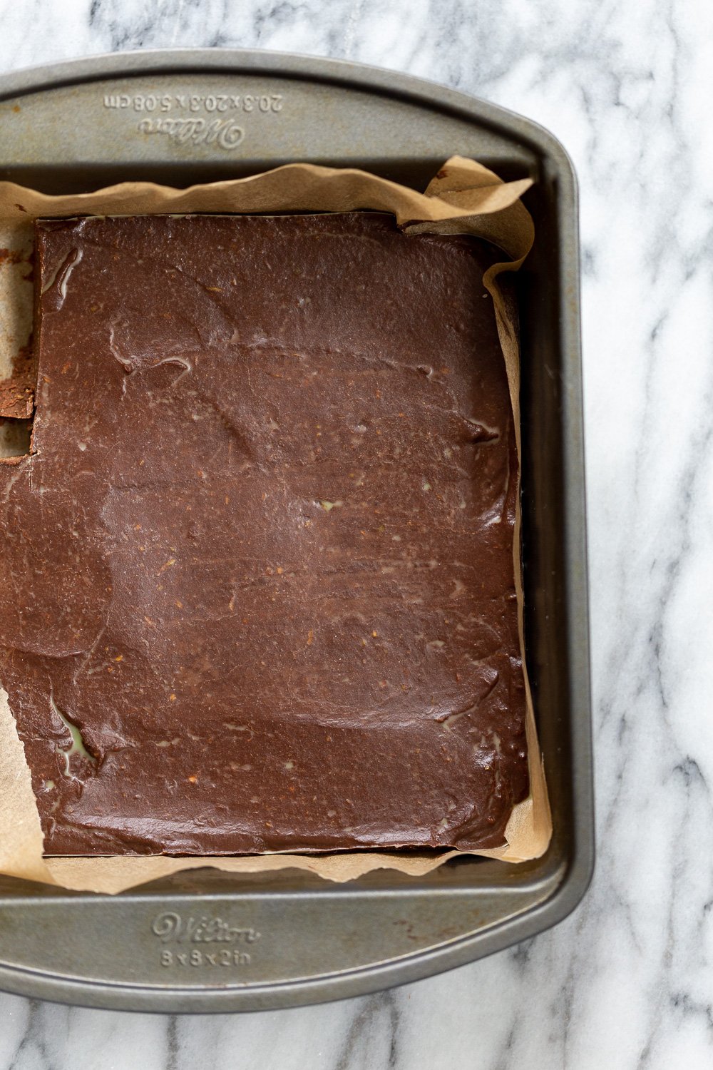 Vegan Chocolate Avocado Freezer Fudge in parchment lined brownie pan