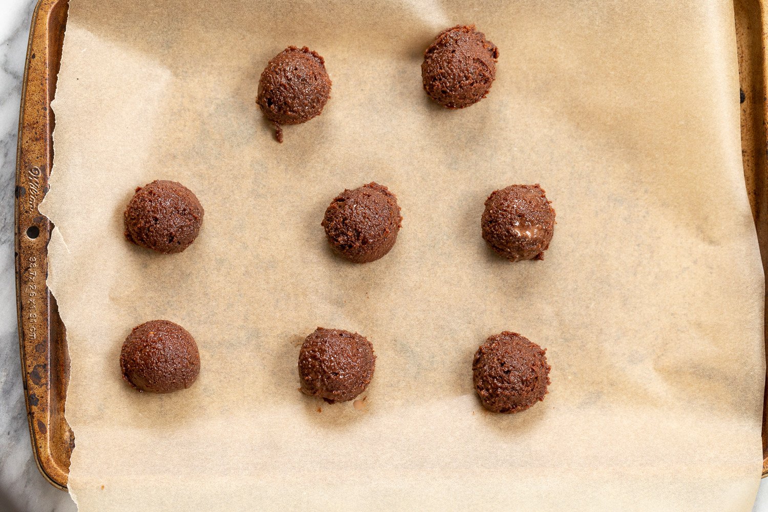 Vegan Brownie Cookie Dough scoop on parchment lined sheet