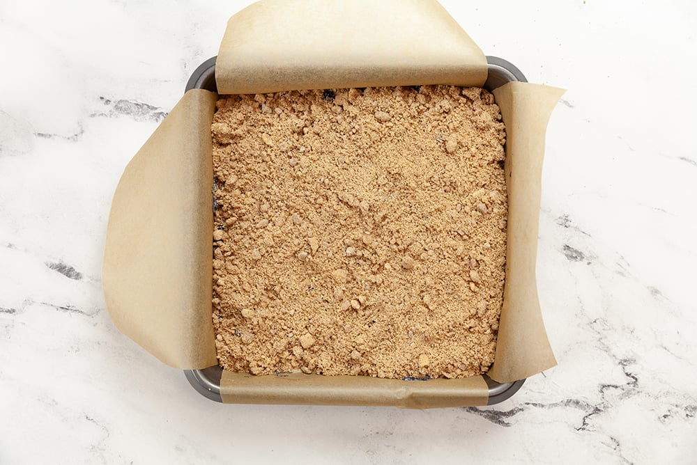 Berry Buckle Batter with streusel in a parchment lined baking dish