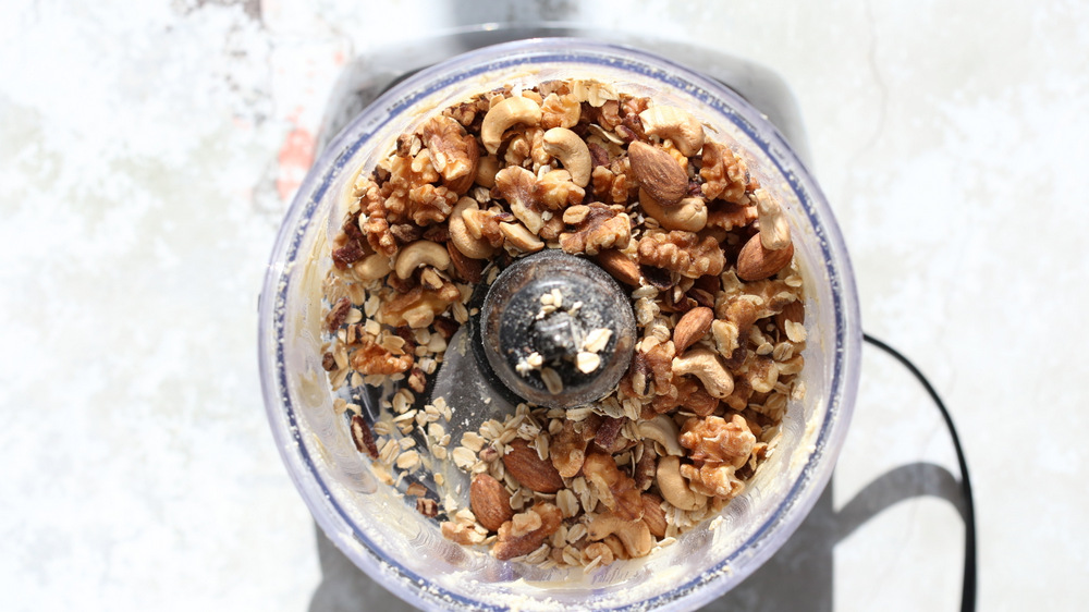 nuts and oats being added to a food processor