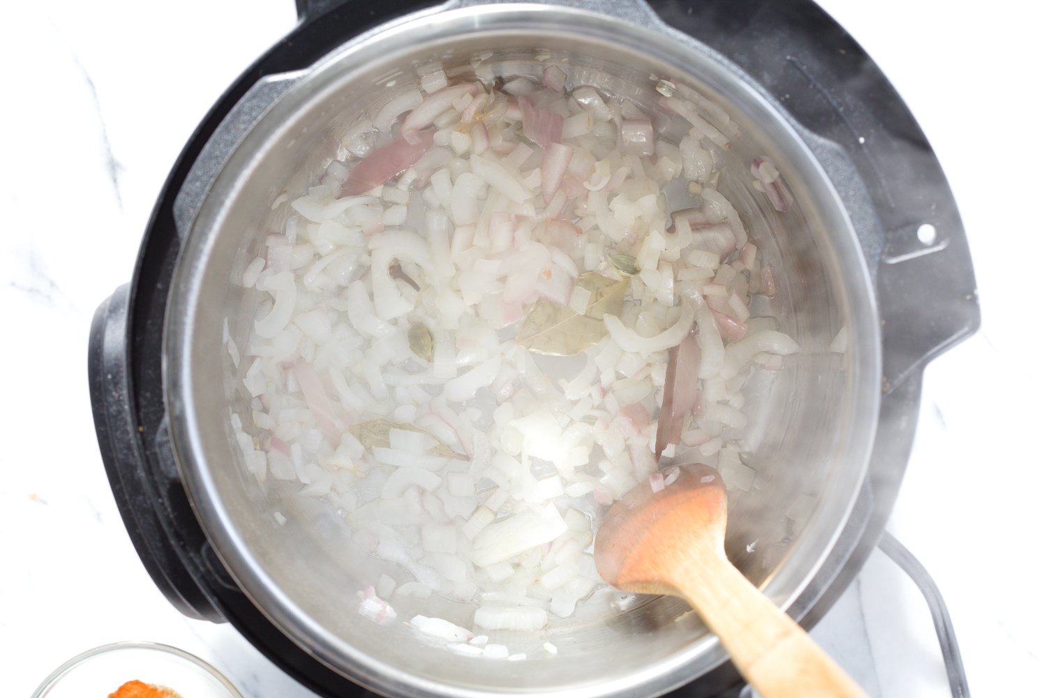 vegan curry recipe minced onions being sauteed in an instant pot to make vegan curry recipe