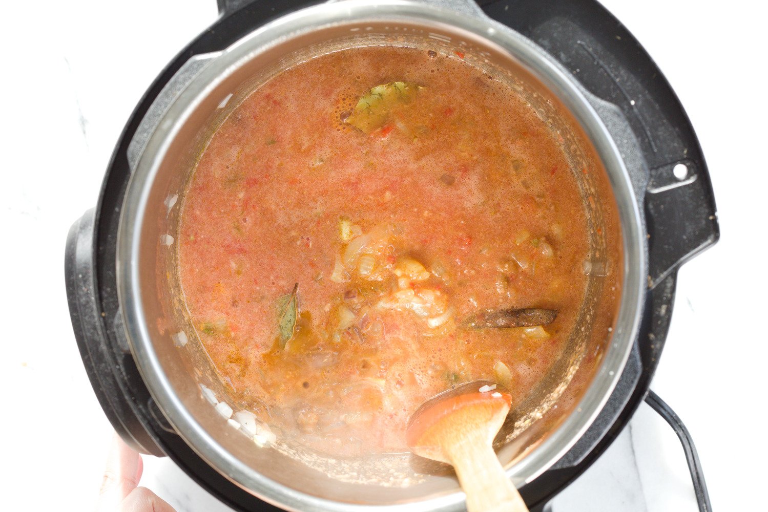 vegan curry recipe  onions, garlic, tomato paste and spices being stirred in an Instant pot to make Vegan curry recipe