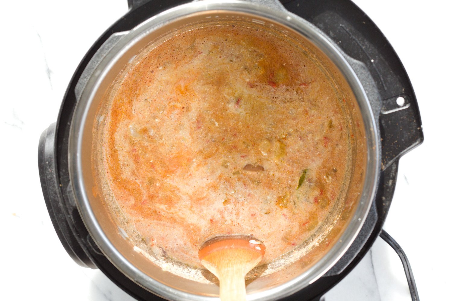 vegan curry recipe  dairy-free milk being stirred into a vegan fenugreek chicken curry made with soy curls