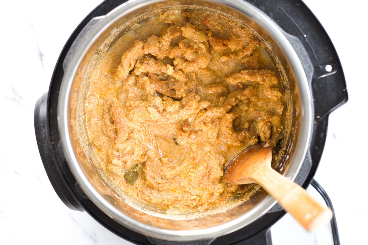 vegan curry recipe  vegan creamy fenugreek curry with soy curls being stirred in an instant pot