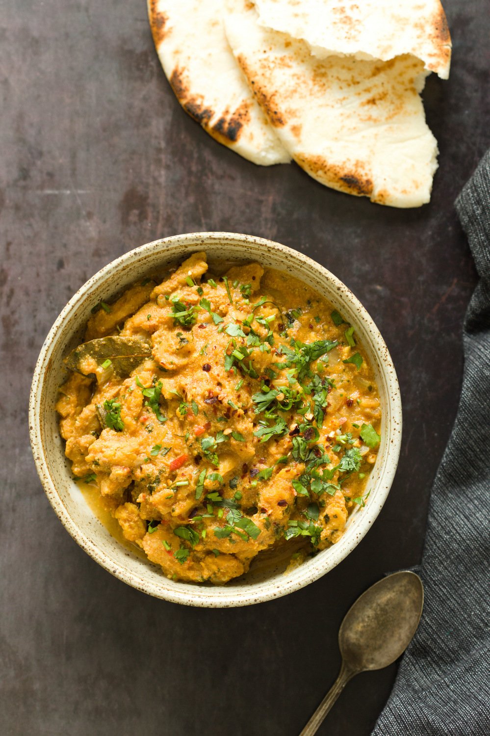 vegan curry recipe  overhead shot of a bowl of vegan methi chicken with some naan bread on the side