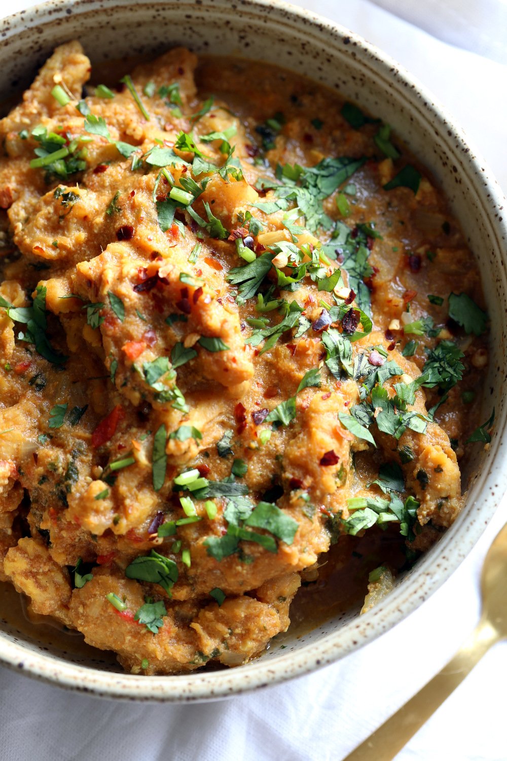 vegan curry recipe  overhead shot of a bowl of vegan fenugreek chicken curry topped with chopped cilantro