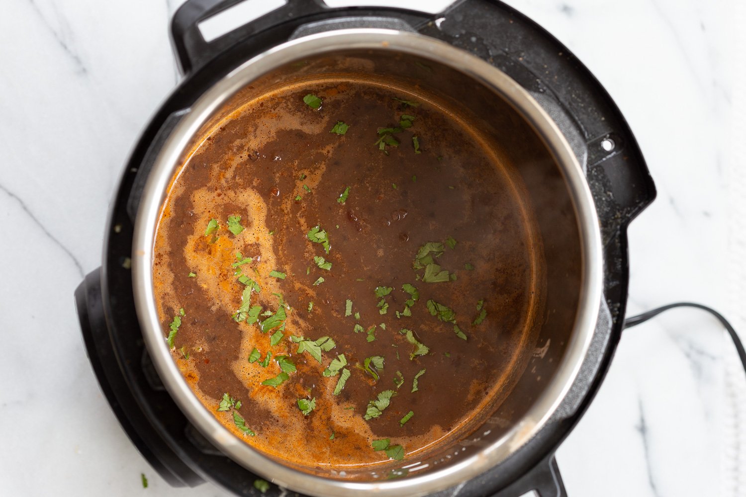 vegan black bean soup  overhead shot of vegan black bean soup simmering in an Instant Pot
