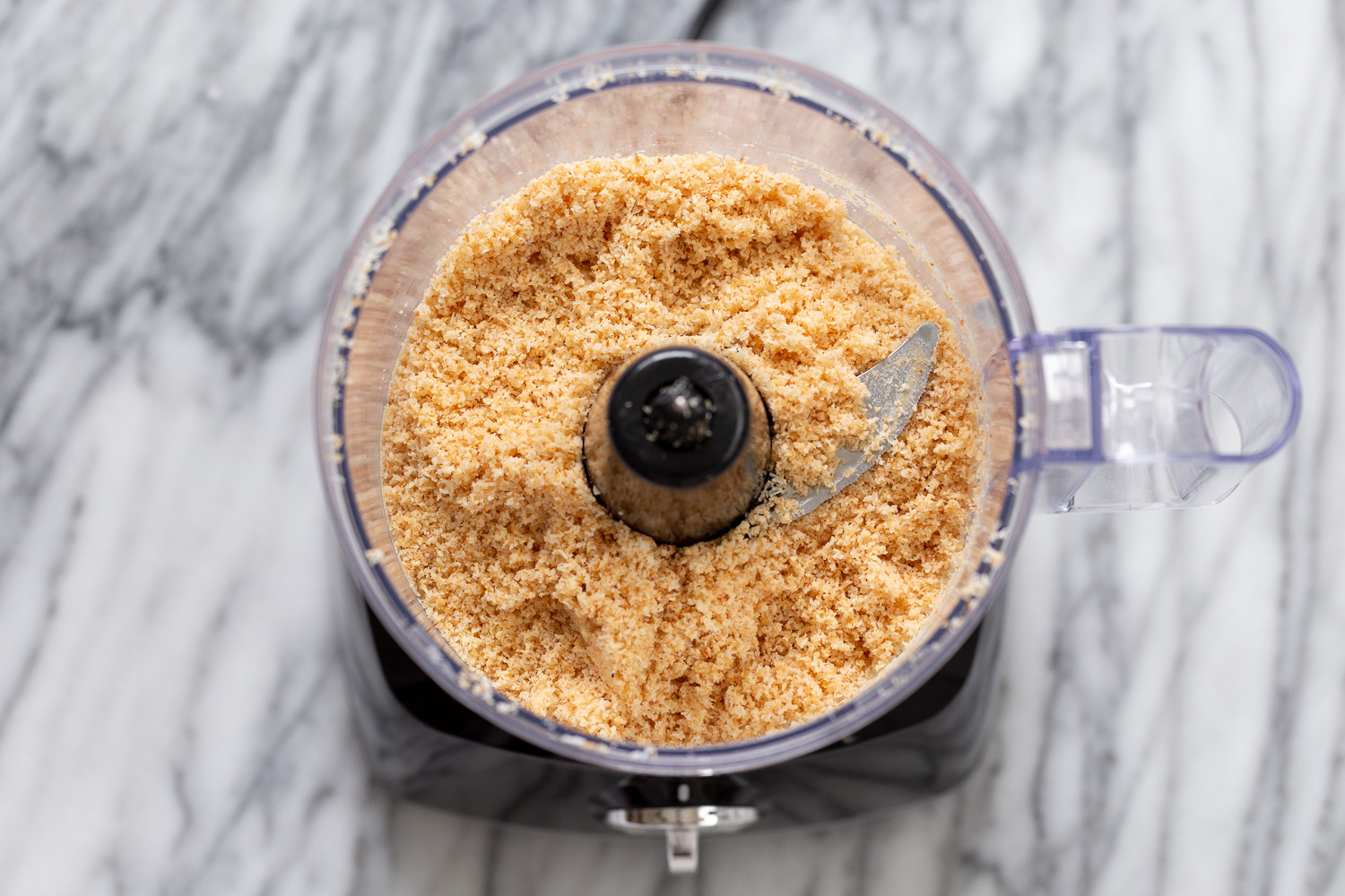 coconut balls  overhead shot of a food processor filled with toasted coconut
