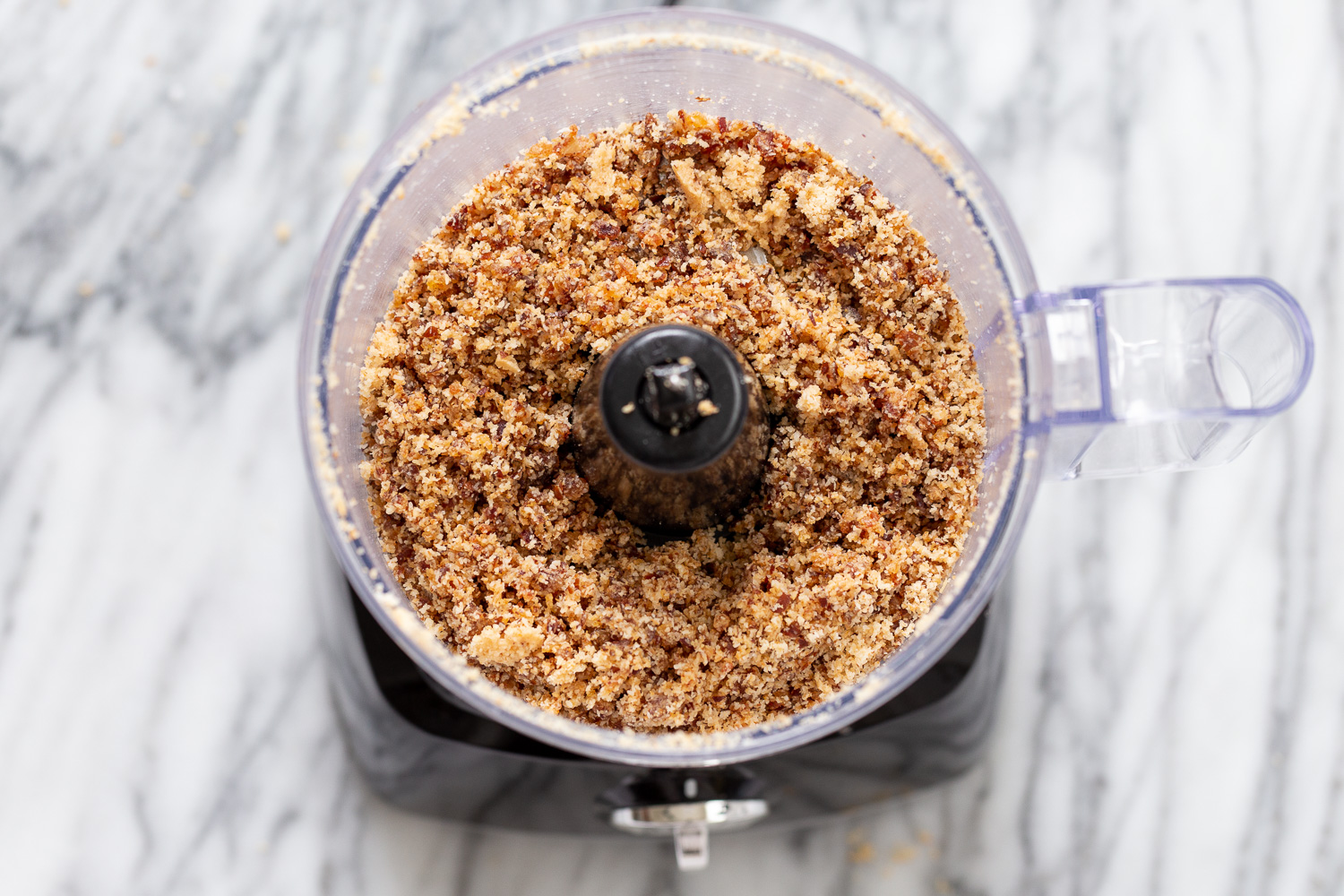 coconut balls  shredded coconut and dates in the container of a food processor