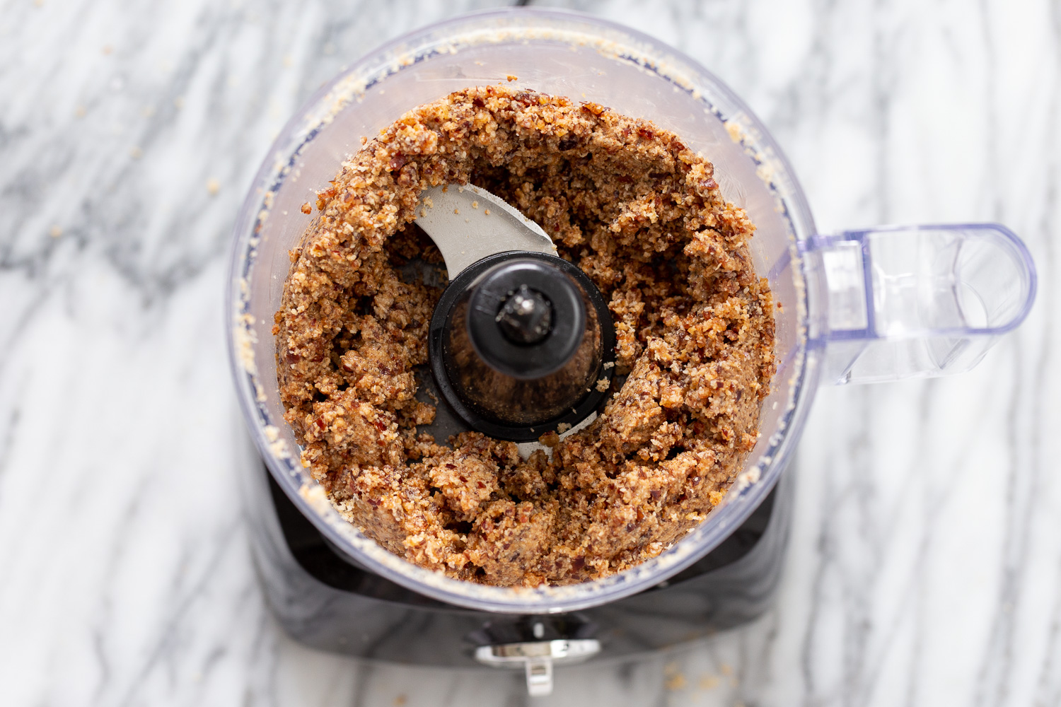coconut balls  coconut dates and almond butter being blended in a food processor to make vegan energy balls