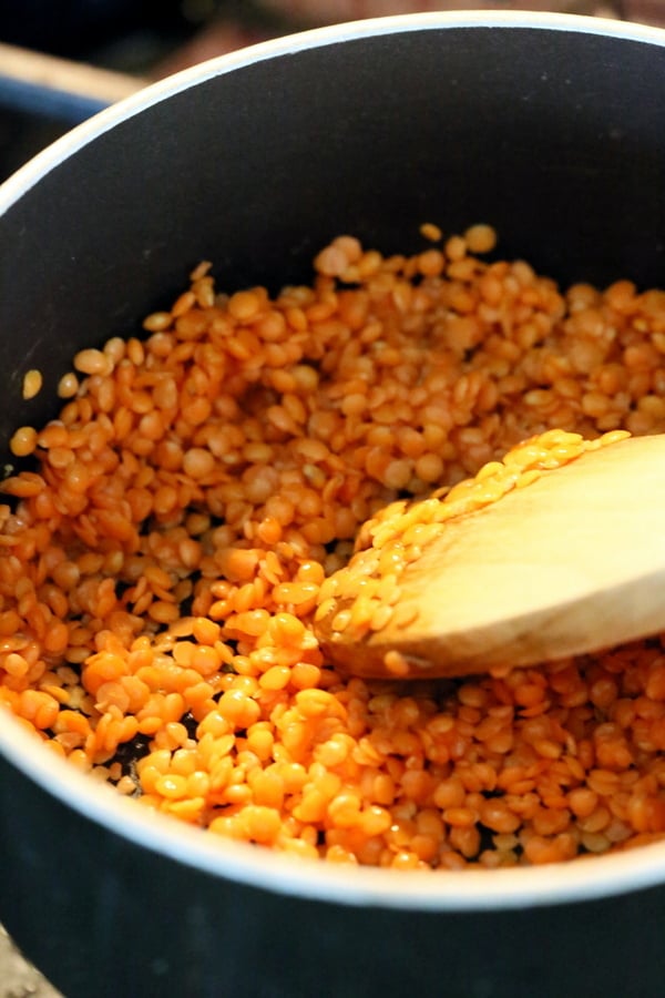 red lentils toasting in a small black saucepan