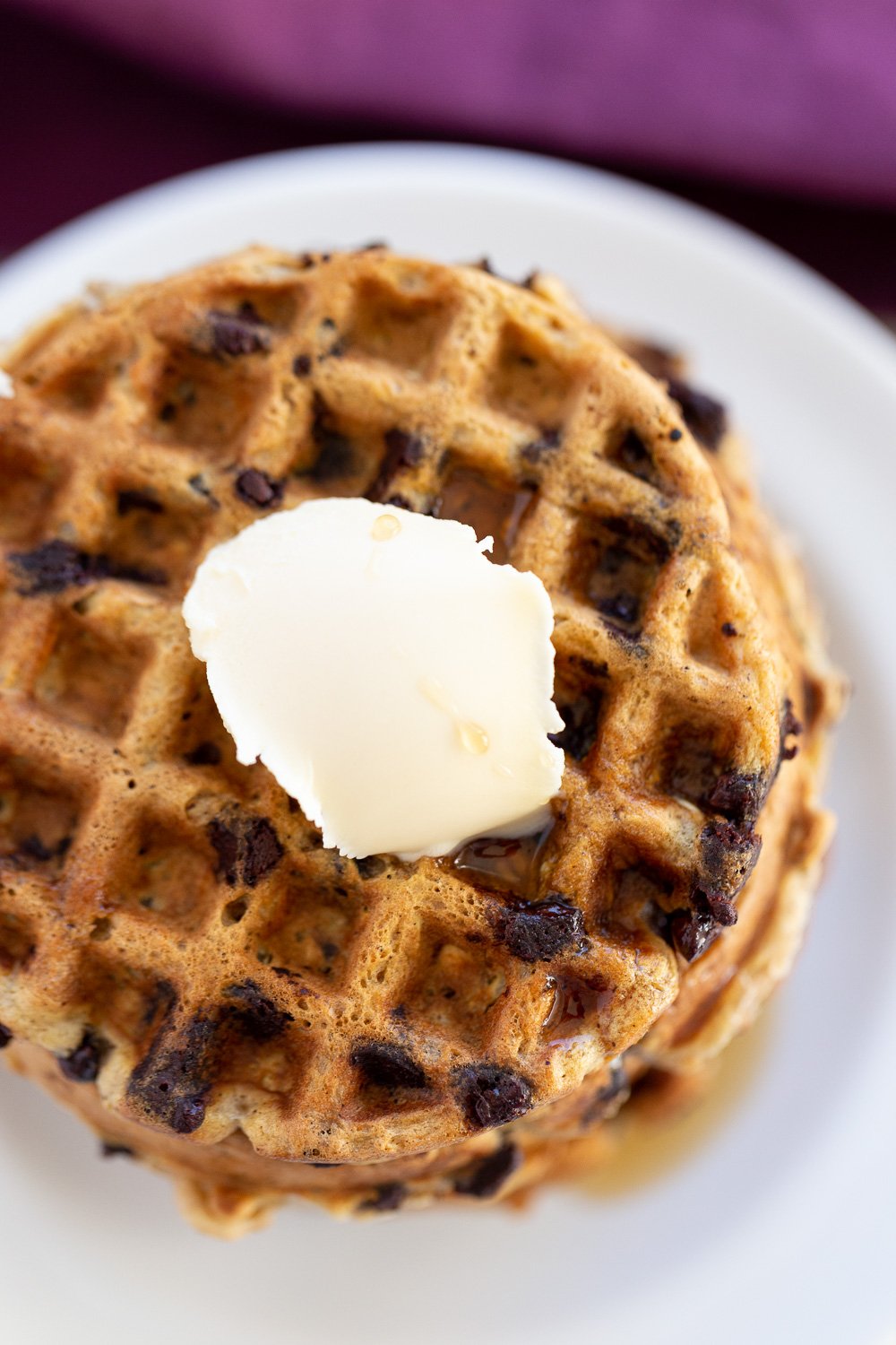 overhead shot of a stack of healthy vegan oatmeal chocolate chip waffles topped with ice cream
