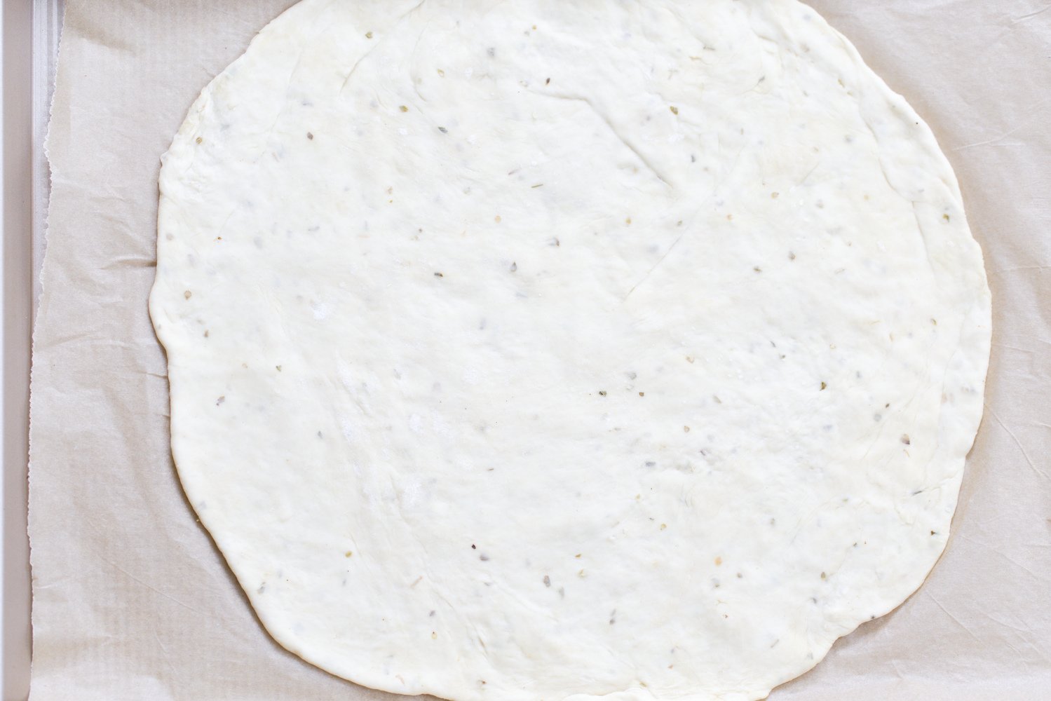 yeast free pizza dough rolled out pizza dough on parchment paper