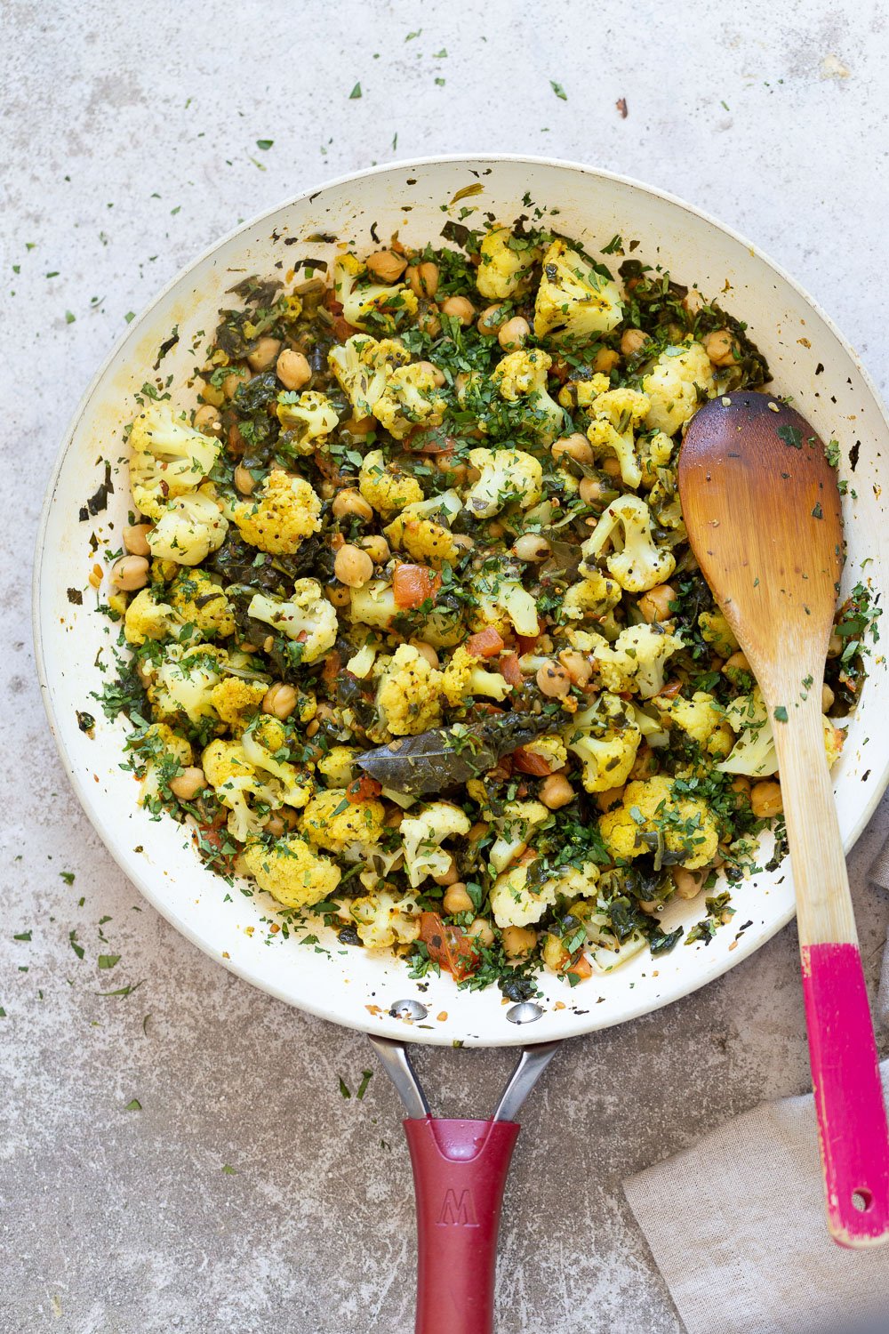spinach and chickpeas overhead shot of a pan with cauliflower, chickpeas and spinach sauteed with Indian spices