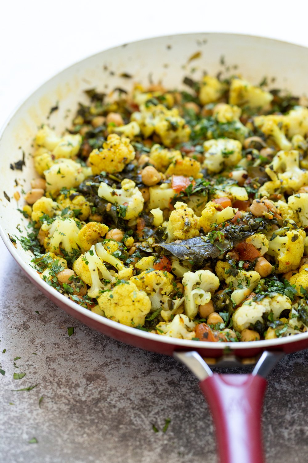 chickpeas and spinach  side view of a pan with cauliflower, chickpeas and spinach sauteed with Indian spices